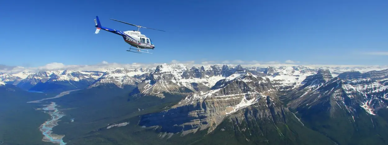 Helicopter flying toward the Canadian Rockies